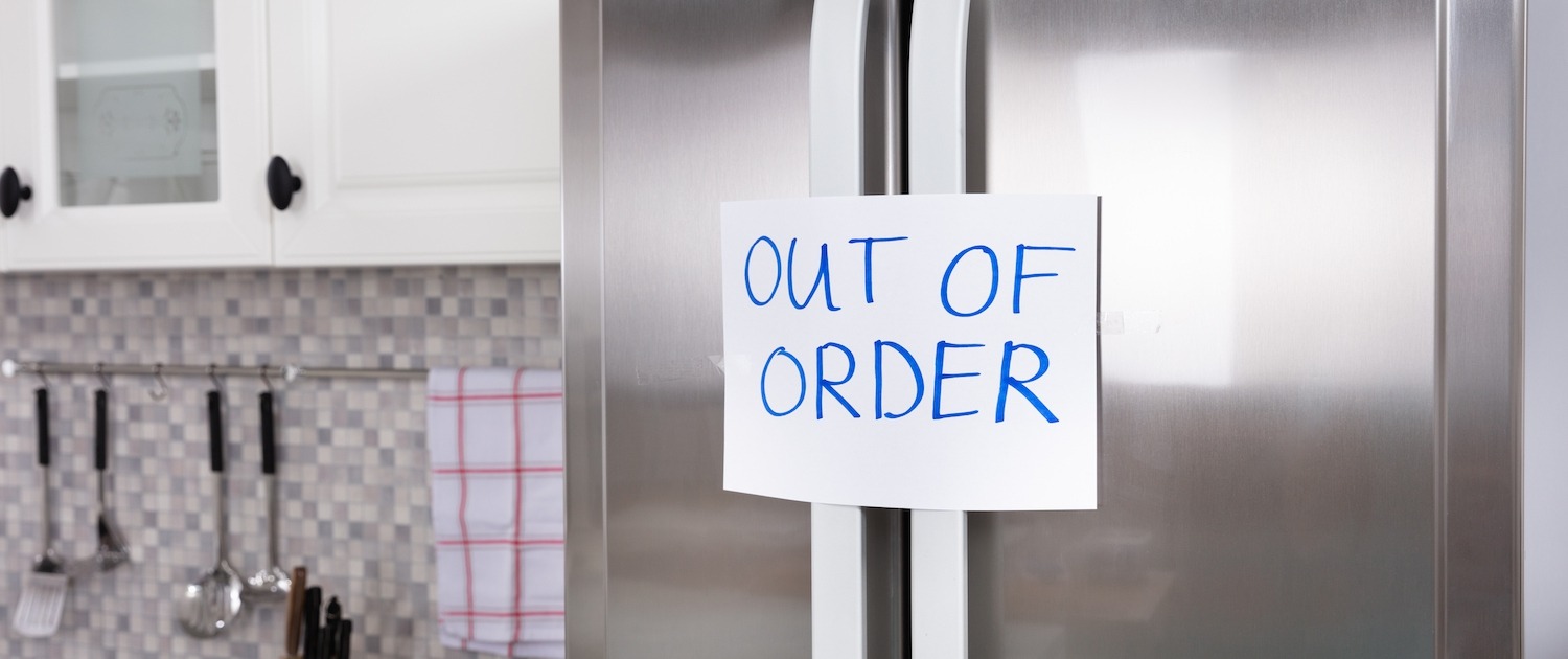 "Out Of Order" Message On Paper Over The Stuck Closed Refrigerator In Kitchen