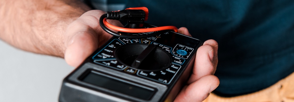 A person holds a multimeter