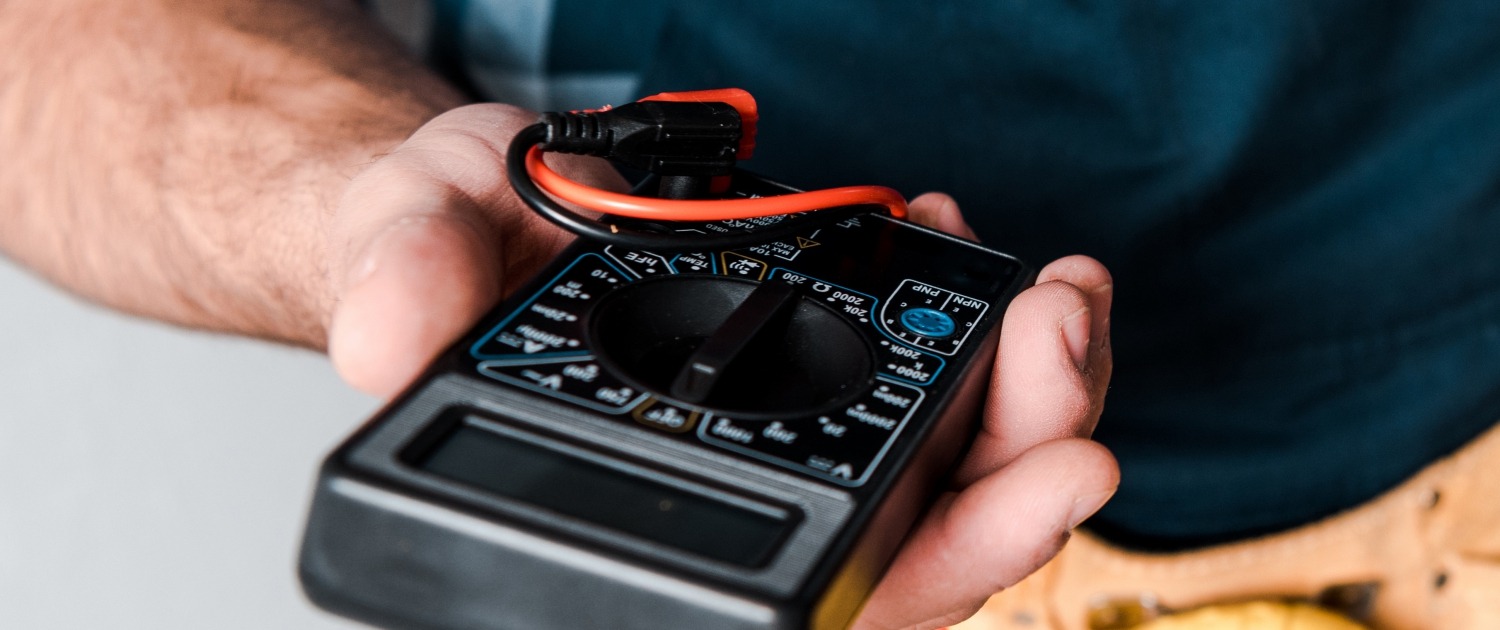 A person holds a multimeter