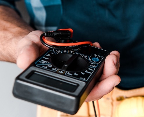 A person holds a multimeter