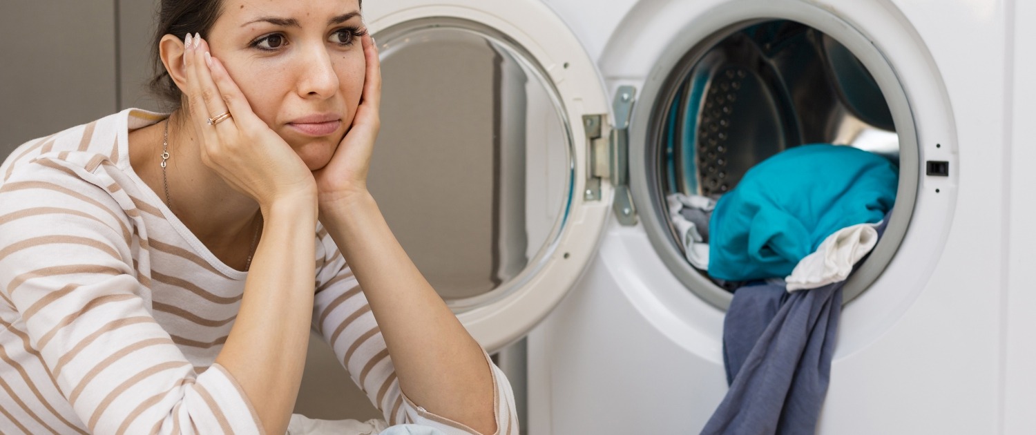Stressed woman doing laundry, picture by Freepik