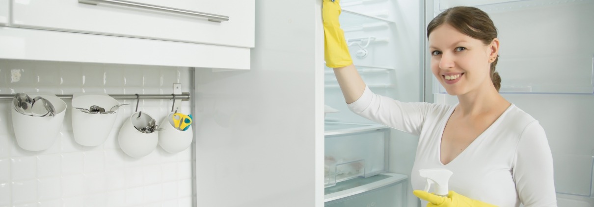 Young smiling woman wearing rubber gloves cleaning the fridge, photo by Yanalya on Freepik.com