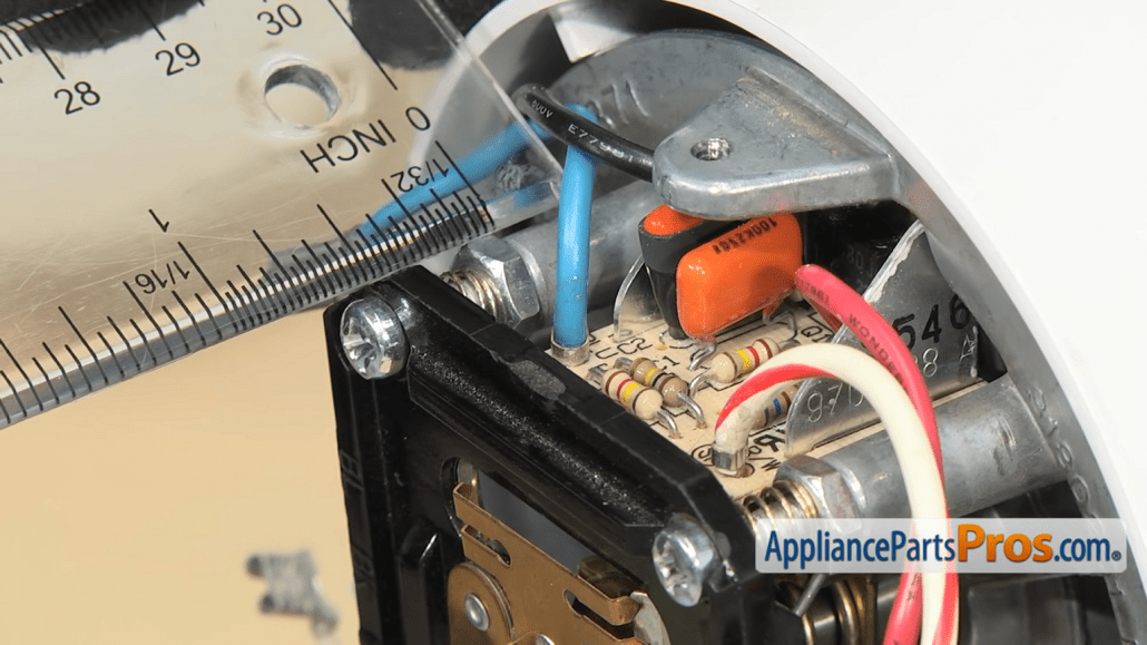 Gloved hands use a ruler to measure inside the KitchenAid mixer