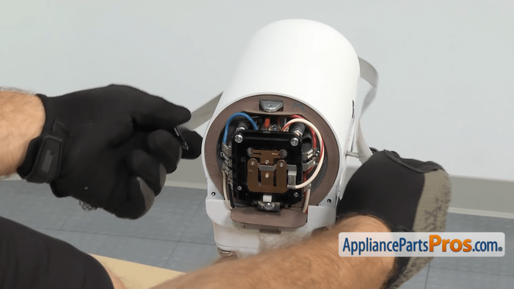 Gloved hands remove the decorative trim on a KitchenAid mixer