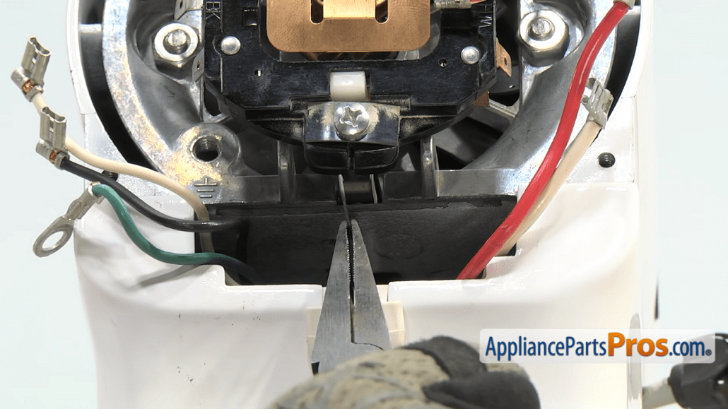 Gloved hands use a pair of pliers inside the KitchenAid mixer