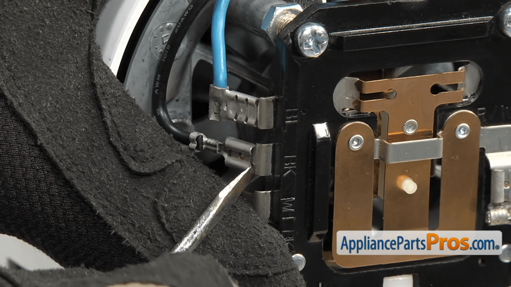 Gloved hands disconnecting wires inside the KitchenAid stand mixer.