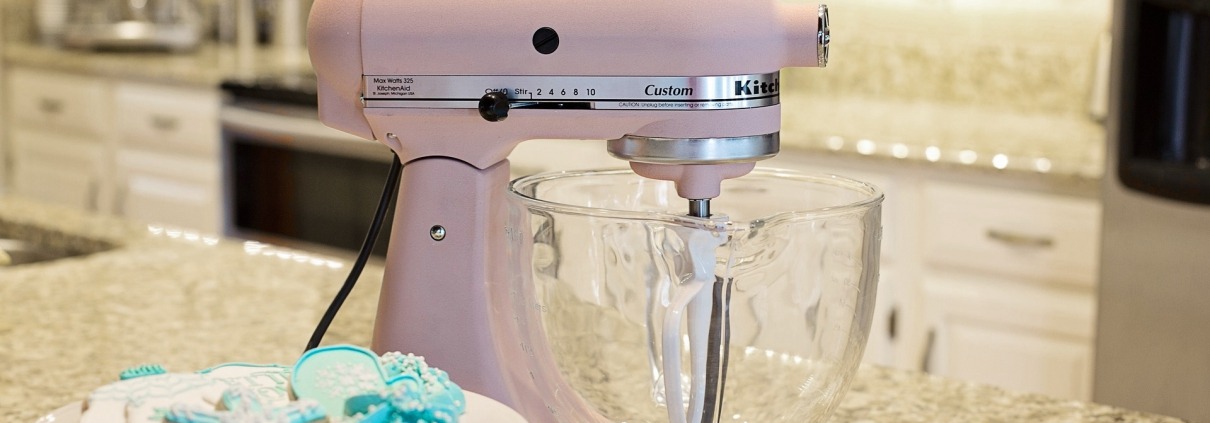Pink stand mixer beside teal snowflake cookies