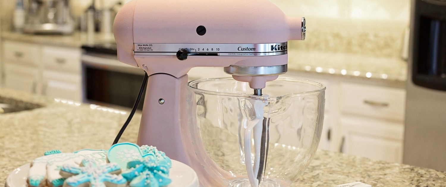 Pink stand mixer beside teal snowflake cookies