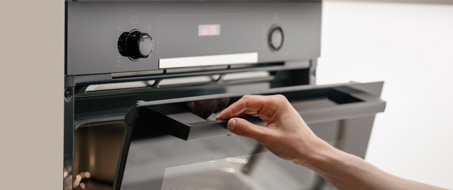 Hand opening an oven door