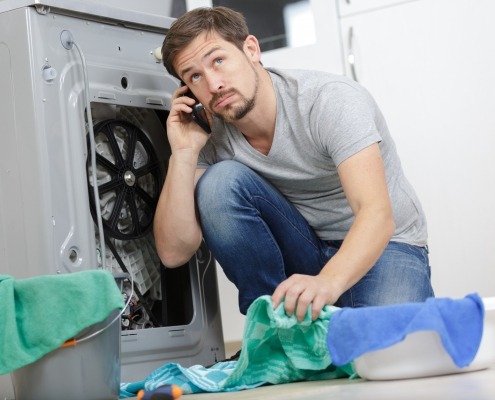 Man on the phone trying to Replace A Dryer Drum Belt