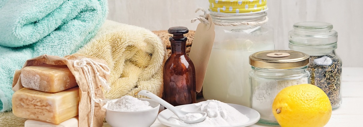 laundry detergent, baking soda, vinegar, and lemon on table; laundry cleaning chemical guide