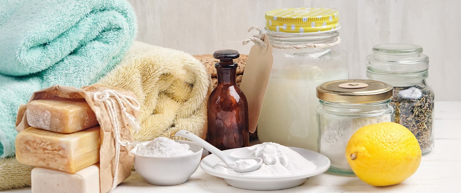laundry detergent, baking soda, vinegar, and lemon on table; laundry cleaning chemical guide