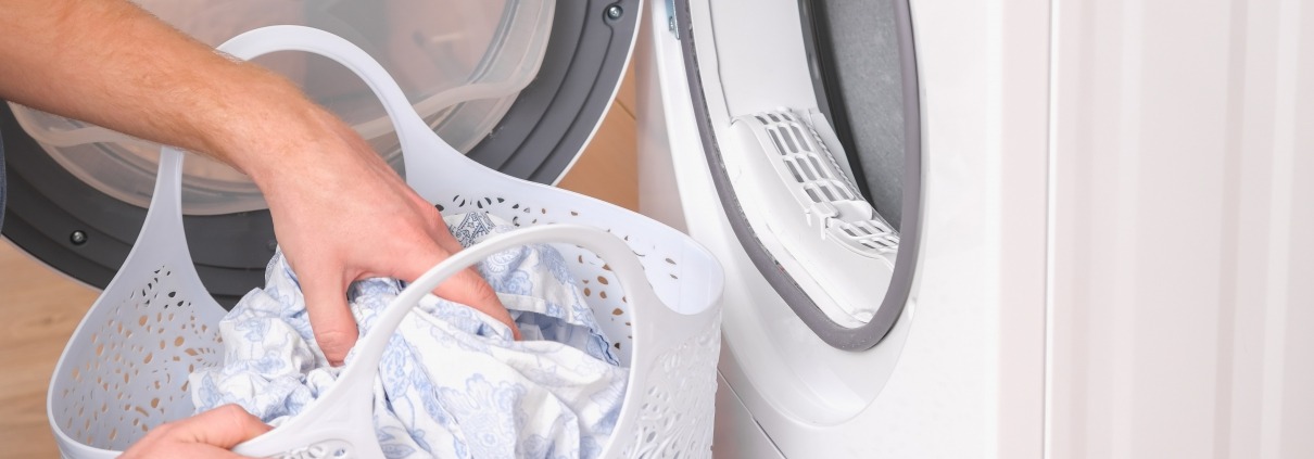 hands grabbing laundry in front of a dryer