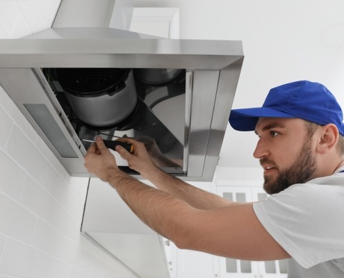 Man Repairing Kitchen Exhaust Fan or Range Hood That Isn't Pulling Air