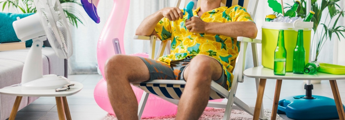 Man cooling himself with electric fans to beat the heat in summer