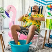 Man cooling himself with electric fans to beat the heat in summer