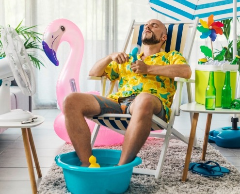 Man cooling himself with electric fans to beat the heat in summer