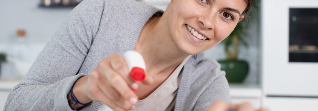 Woman smiling while cleaning the kitchen