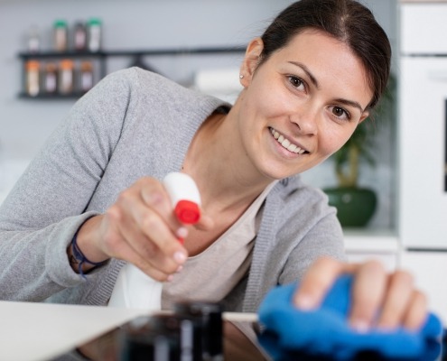Woman smiling while cleaning the kitchen