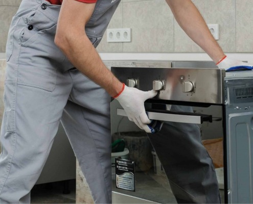Step-by-step installation of an electric oven, showing it being carefully positioned and secured in place.