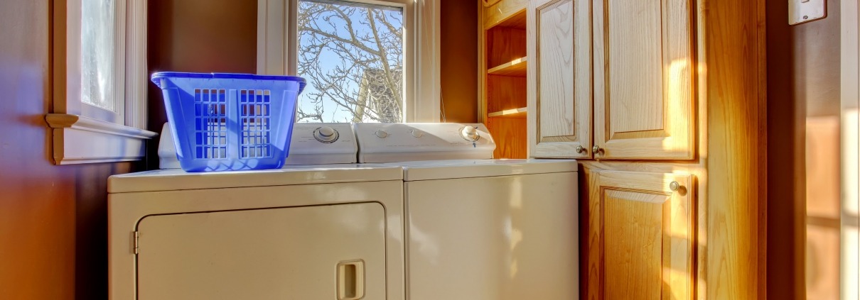 Small laundry room with wooden cabinet