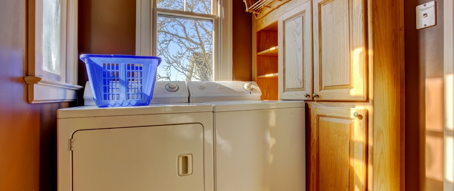 Small laundry room with wooden cabinet