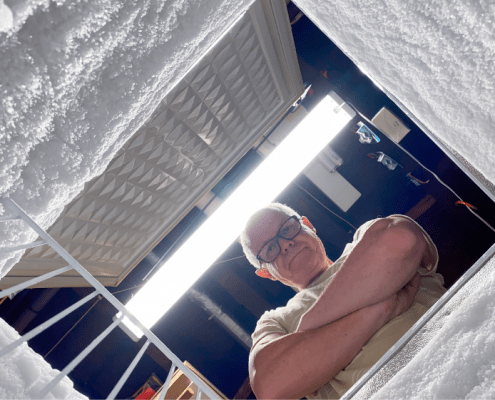 older man looking into chest freezer
