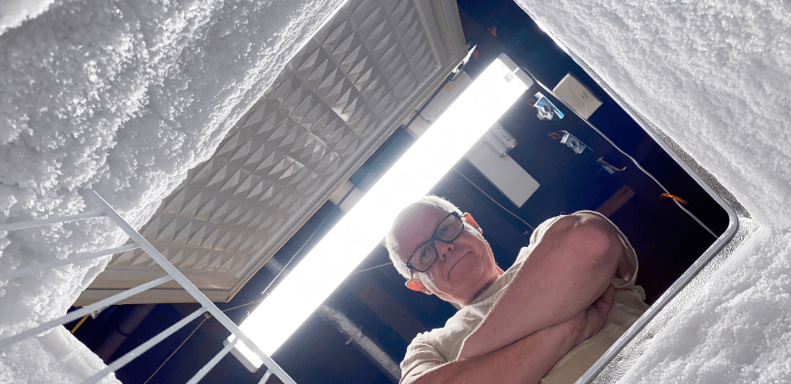older man looking into chest freezer
