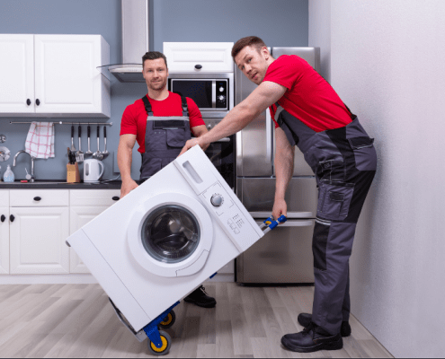 two men moving household appliances on a dolly