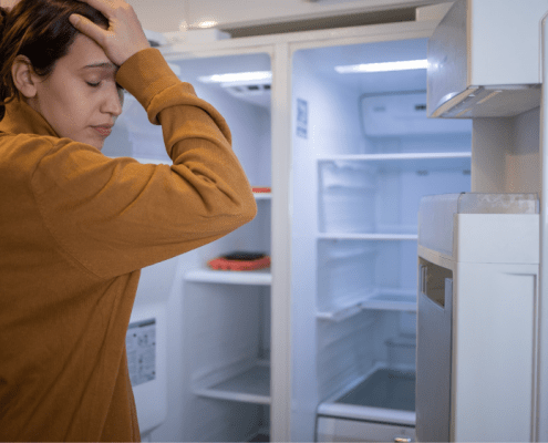 Woman frustrated by her refrigerator not cooling