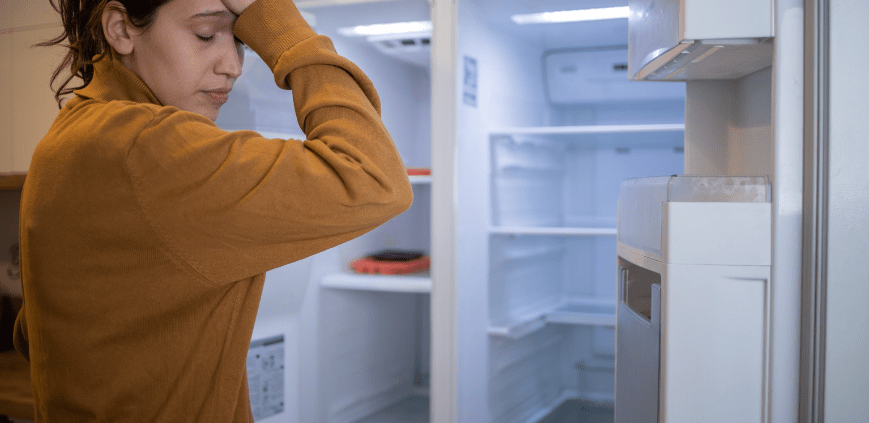 Woman frustrated by her refrigerator not cooling