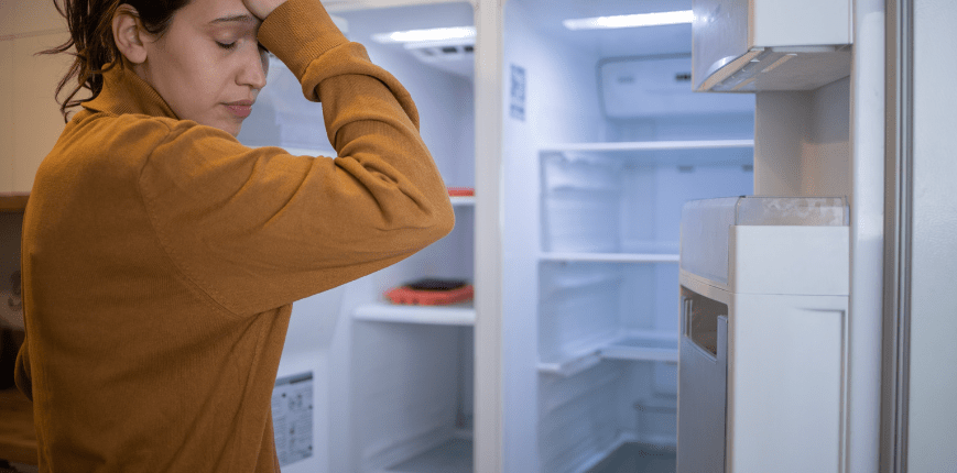 Woman frustrated by her refrigerator not cooling
