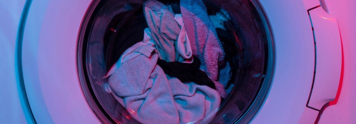 garments spinning around in washing machine getting cleaned during cycle using the correct water temperature