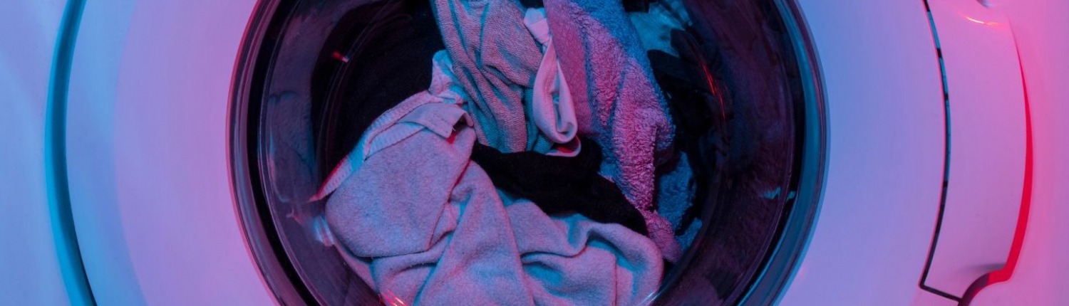 garments spinning around in washing machine getting cleaned during cycle