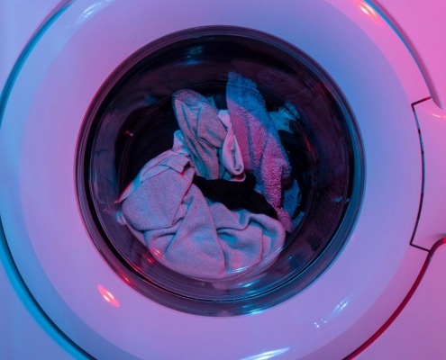 garments spinning around in washing machine getting cleaned during cycle using the correct water temperature