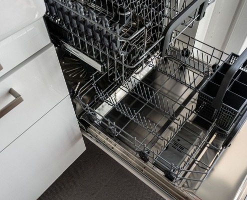 Dishwasher pulled out to inspect dishwasher insulation