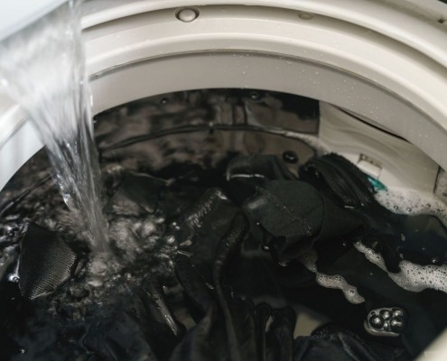washing machine full of clothes filling up with water