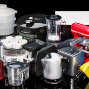 various colored small kitchen appliances displayed on black countertop
