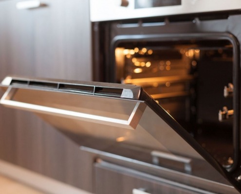 stainless steel oven door open in modern kitchen