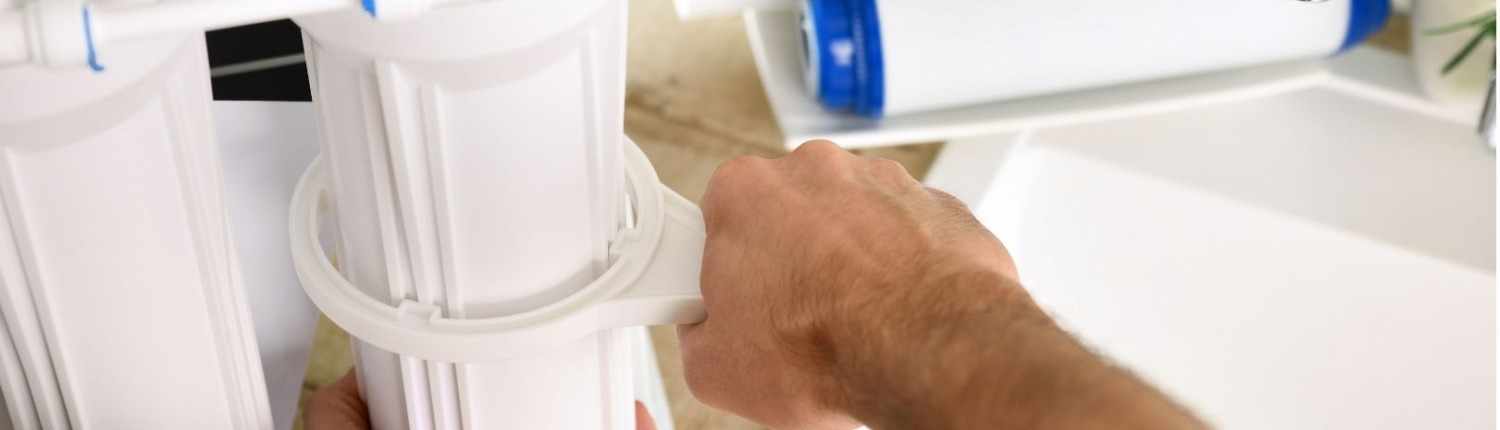man mounting water filter system
