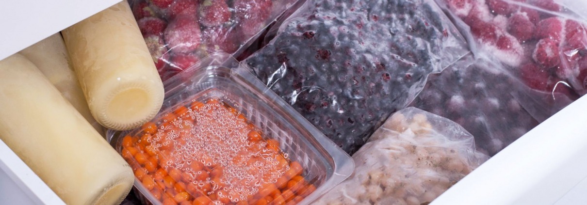 fresh fruits and vegetables sealed in bags within open freezer drawer