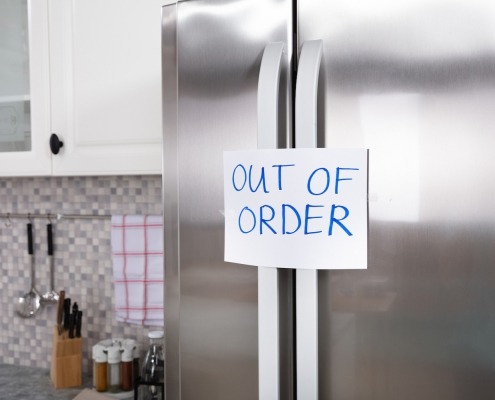 "Out Of Order" Message On Paper Over The Stuck Closed Refrigerator In Kitchen