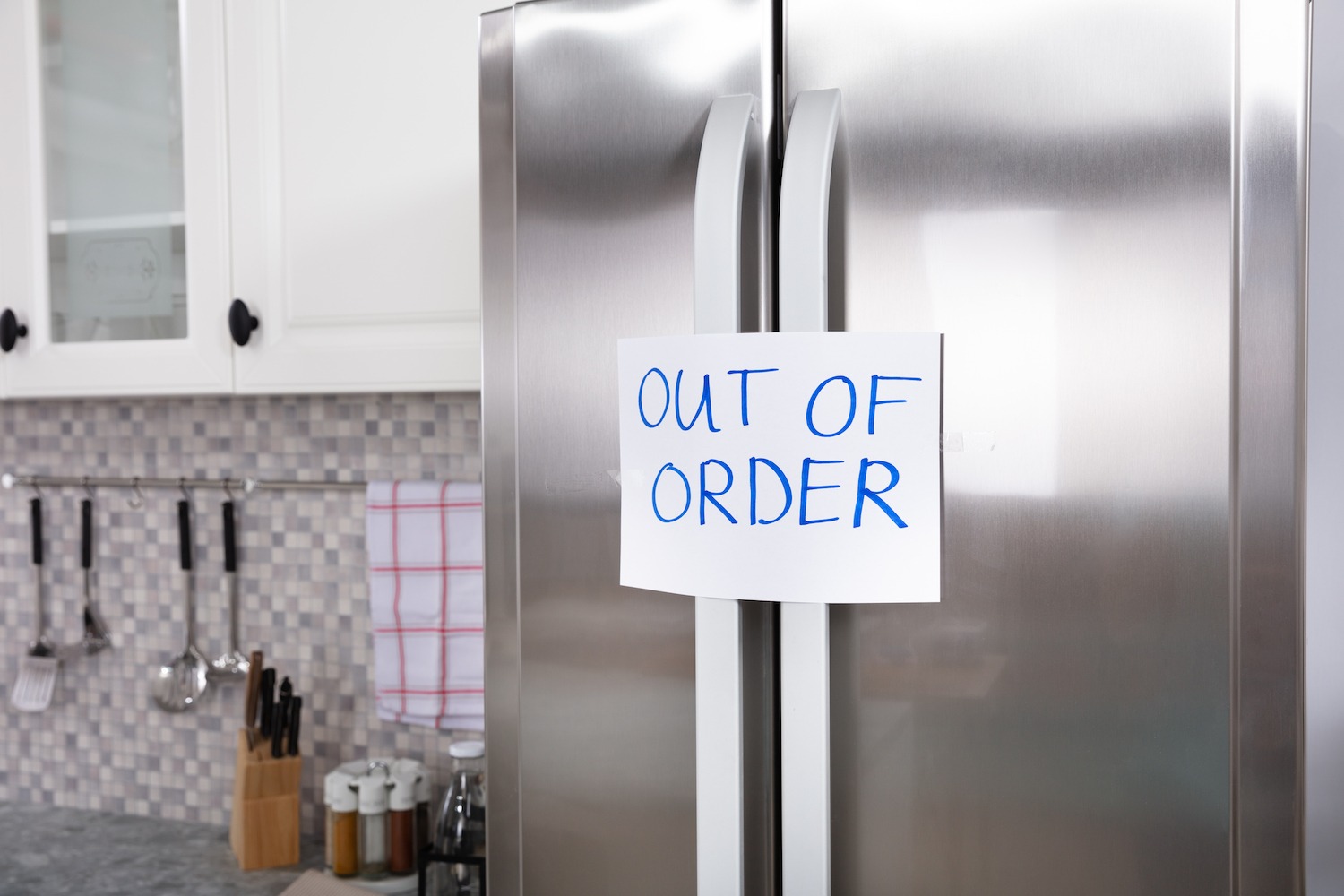 "Out Of Order" Message On Paper Over The Stuck Closed Refrigerator In Kitchen