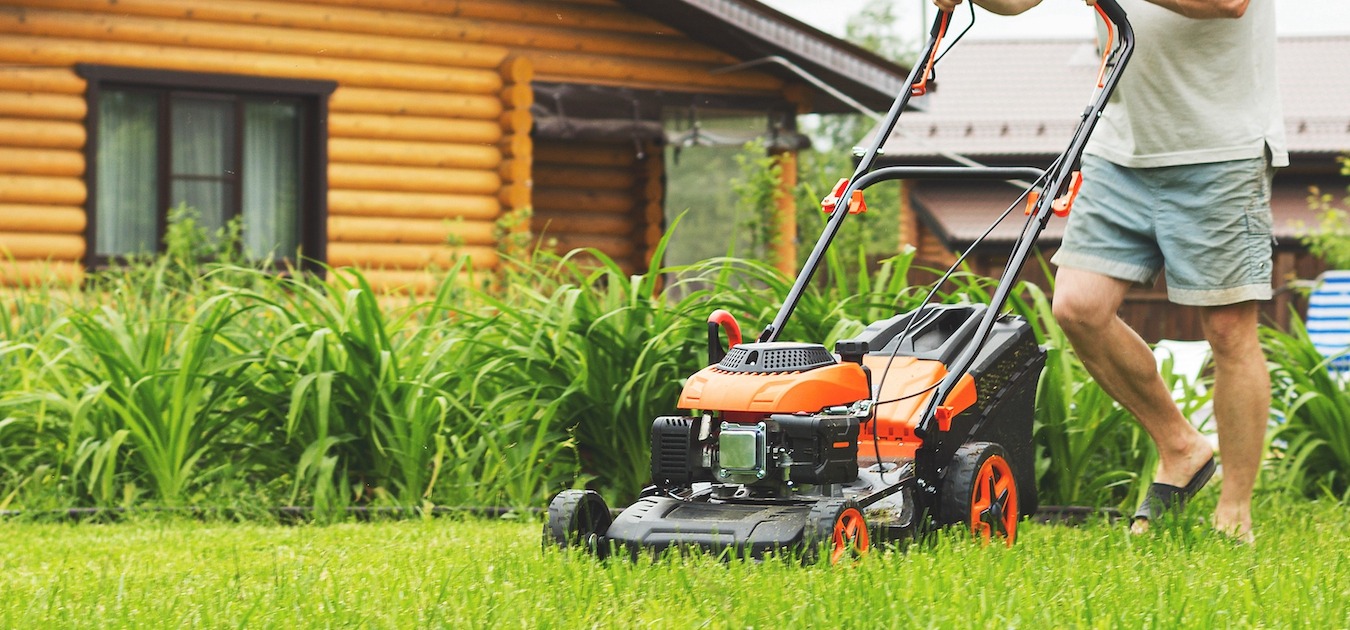 Man,In,Shorts,Mowing,The,Grass,On,The,Lawn.,Young