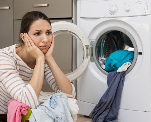 Stressed woman doing laundry, picture by Freepik