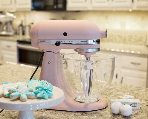 Pink stand mixer beside teal snowflake cookies