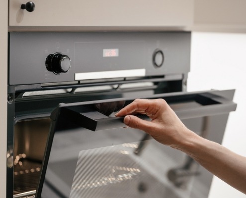 Hand opening an oven door