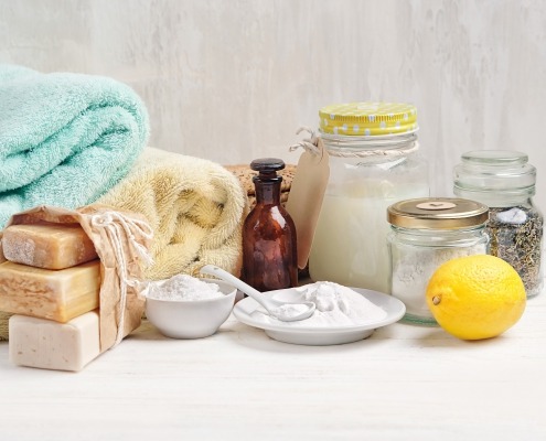 laundry detergent, baking soda, vinegar, and lemon on table; laundry cleaning chemical guide