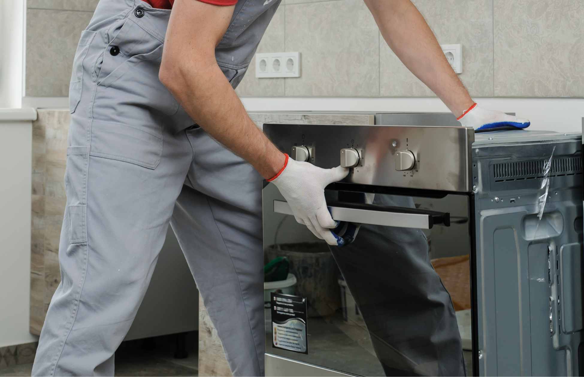 Step-by-step installation of an electric oven, showing it being carefully positioned and secured in place.
