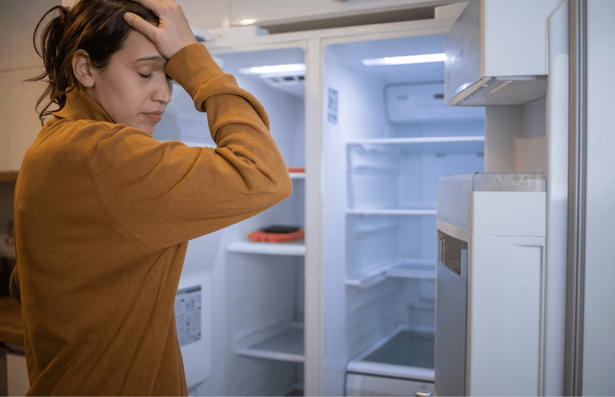 Woman frustrated by her refrigerator not cooling